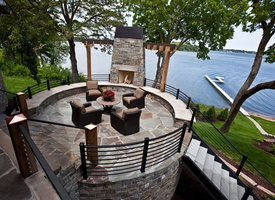 12 Deck-Design -Patio-deck-with-outdoor-fireplace-stone-flooring-modern-deck-railing-stone-siding-all-to-take-advantage-of-the-amazing-lake-view -Deck-Patio-E